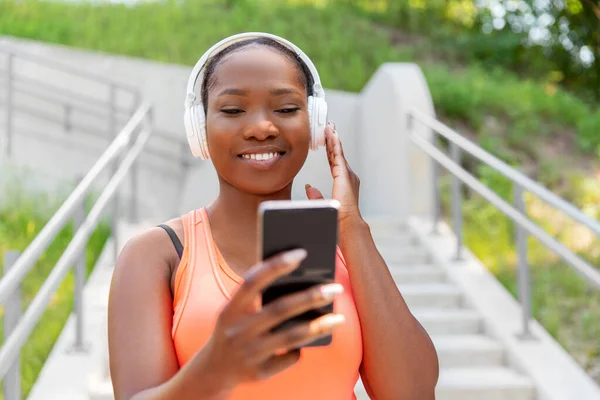 Mujer afroamericana con auriculares y teléfono —  Fotos de Stock