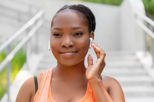 Mulher americana africana feliz com fones de ouvido — Fotografia de Stock