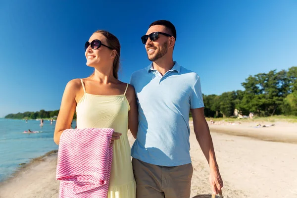 Szczęśliwa para z koszykiem piknikowym spacerująca po plaży — Zdjęcie stockowe