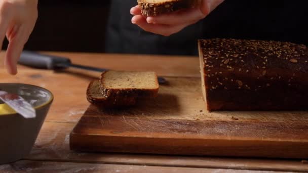 Boulanger femelle étalant du beurre sur du pain fait maison — Video