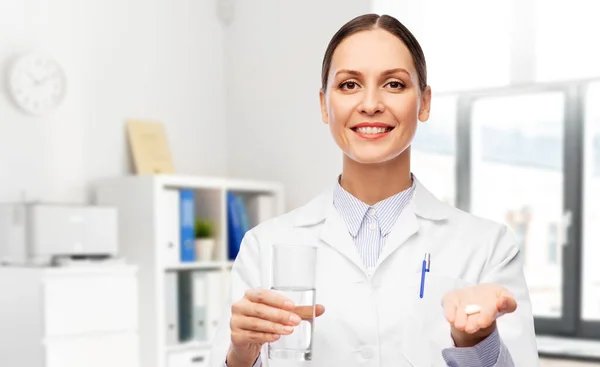Medico femminile con medicina e bicchiere d'acqua — Foto Stock
