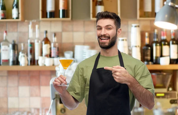Barman em avental com copo de coquetel no bar — Fotografia de Stock