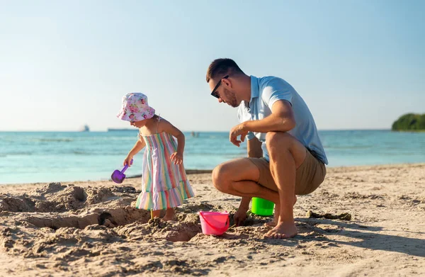 Padre e hija jugando con juguetes en la playa — Foto de Stock