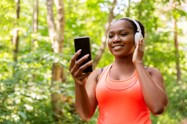 Donna afroamericana con cuffie e telefono — Foto Stock