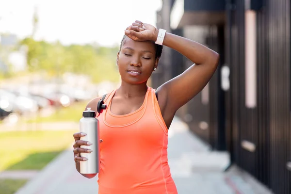 Уставшая африканская американка с бутылкой воды — стоковое фото