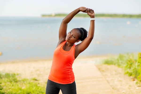 Young african american woman stretching outdoors — Stock Photo, Image