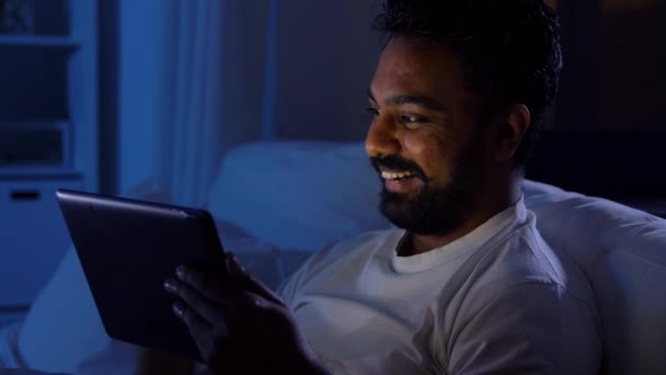 インド人男性とタブレットPCベッドで自宅で夜 — ストック動画