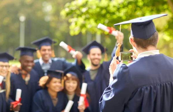 Afgestudeerde studenten fotograferen met smartphone — Stockfoto