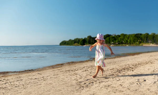 Χαρούμενο κοριτσάκι τρέχει στην καλοκαιρινή παραλία — Φωτογραφία Αρχείου