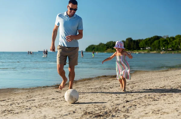 Glücklicher Vater und Tochter spielen Ball am Strand — Stockfoto