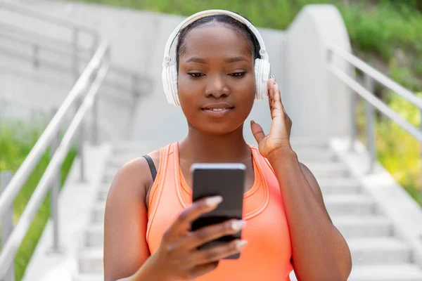 Mujer afroamericana con auriculares y teléfono —  Fotos de Stock