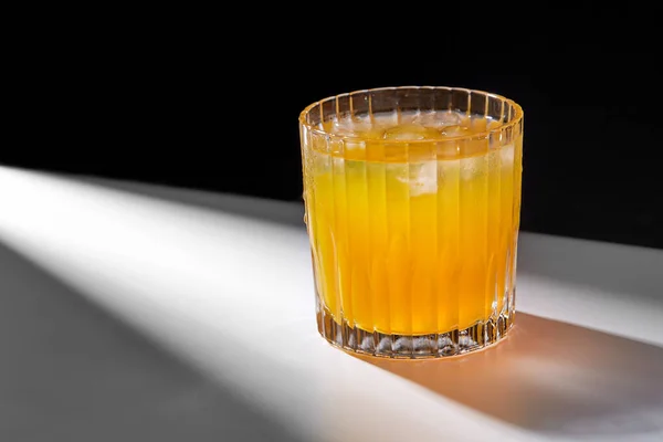 Glas sinaasappelsap met ijs op tafel — Stockfoto