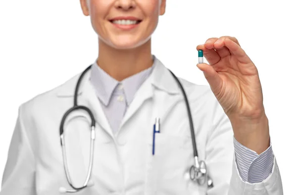 Sorridente médico feminino segurando pílula medicina — Fotografia de Stock