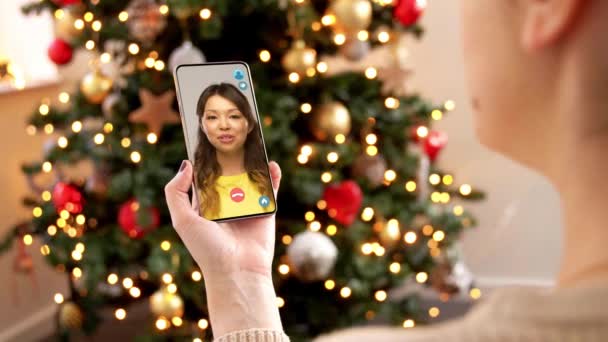 Akıllı telefonlu bir kadının Noel 'de video görüşmesi var. — Stok video