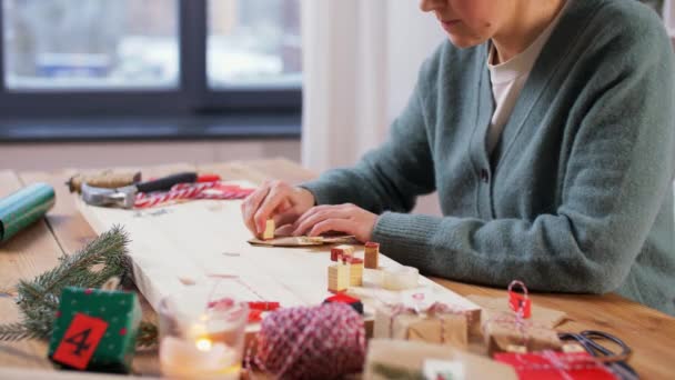 Mujer haciendo calendario de adviento en Navidad en casa — Vídeo de stock