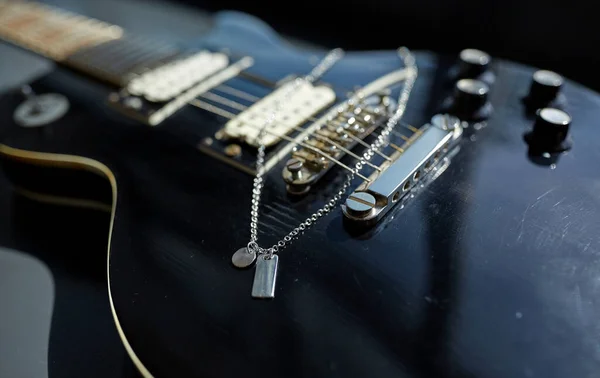 Close-up de guitarra baixo com pingente metálico — Fotografia de Stock