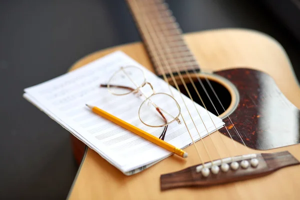 Primo piano di chitarra, libro di musica, matita e occhiali — Foto Stock