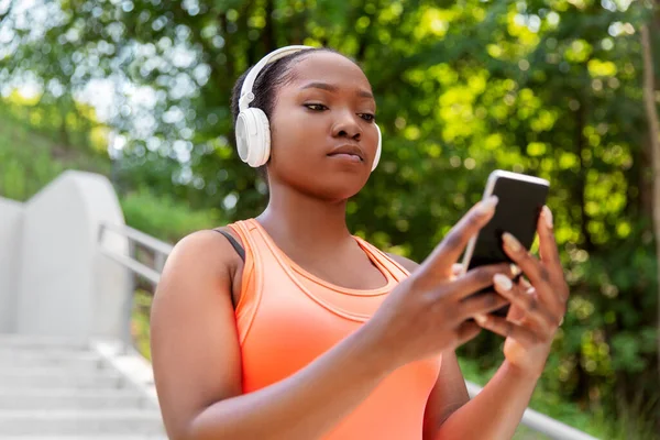 Donna afroamericana con cuffie e telefono — Foto Stock