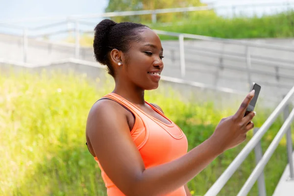 Sporty african woman using smartphone in city — Stock Photo, Image