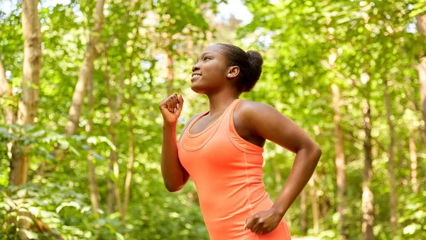 Happy african american woman running in forest — Stock Photo, Image
