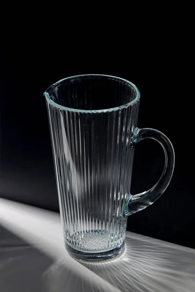 Empty faceted glass jug on table — Stock Photo, Image