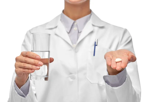 Kadın doktor ilaç ve bir bardak suyla — Stok fotoğraf