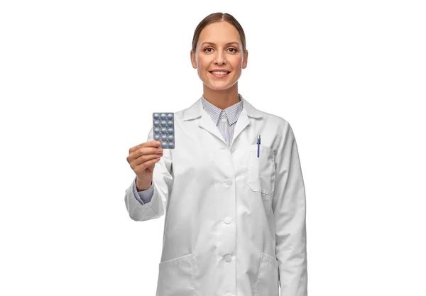 Uśmiechnięta lekarka trzymająca tabletki. — Zdjęcie stockowe