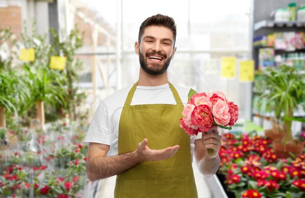 Uśmiechnięty mężczyzna ogrodnik z piwoniami w kwiaciarni — Zdjęcie stockowe