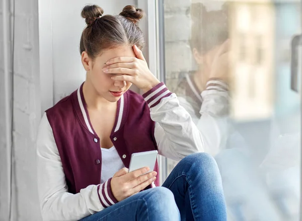 Teenager mit Smartphone auf Fensterbank — Stockfoto