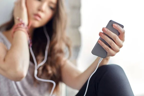 Chica adolescente con teléfono inteligente y auriculares — Foto de Stock