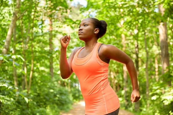 Fiatal afro-amerikai nő fut az erdőben — Stock Fotó