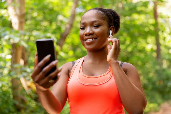 Afrykańska amerykanka ze słuchawkami i telefonem — Zdjęcie stockowe