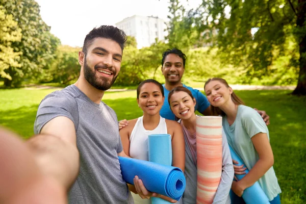 Mensen met yogamatten die selfie nemen in het park — Stockfoto