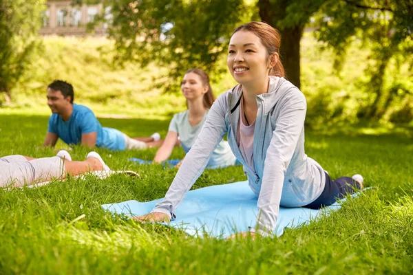 Grupo de personas haciendo yoga en el parque de verano —  Fotos de Stock