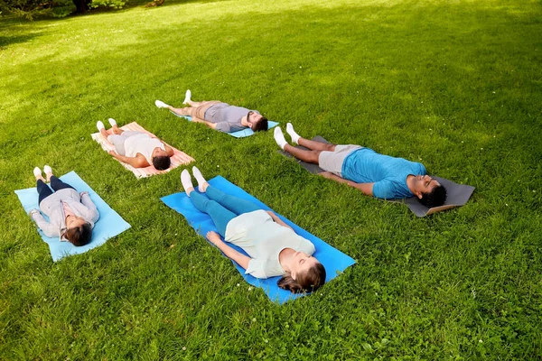 Group of people doing yoga at summer park — Stock Photo, Image