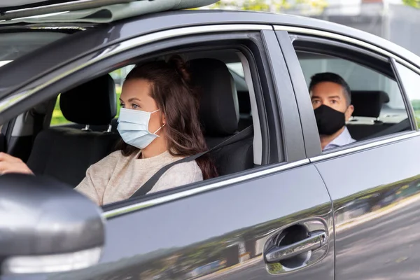 Kvinnlig förare i mask kör bil med passagerare — Stockfoto