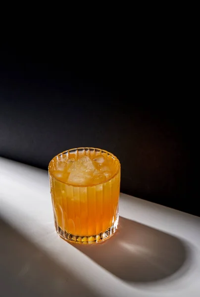 Bicchiere di succo d'arancia con ghiaccio sul tavolo — Foto Stock