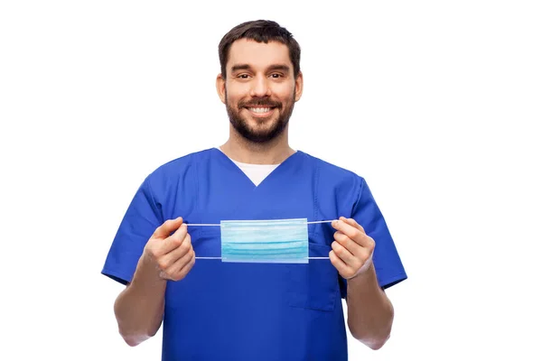 Mosolygós férfi orvos kék egyenruhában maszkkal — Stock Fotó