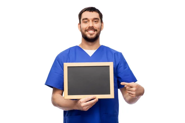 Happy smiling male doctor or nurse with chalkboard — Stock Photo, Image