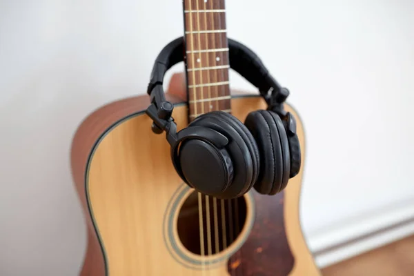Primer plano de la guitarra acústica y auriculares — Foto de Stock