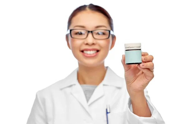 Sonriente médico mujer sosteniendo frasco de medicina — Foto de Stock