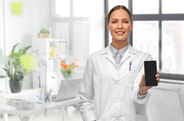 Doctora sonriente con smartphone en el hospital —  Fotos de Stock