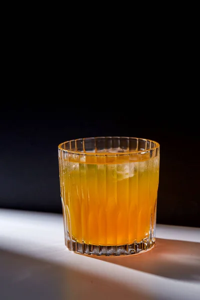 Vidro de suco de laranja com gelo na mesa — Fotografia de Stock