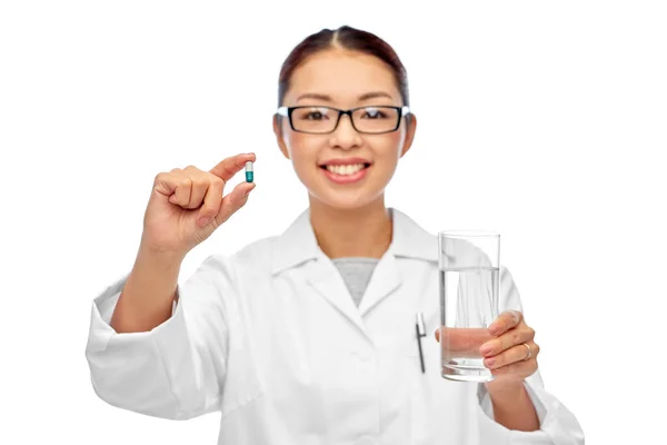 Asiatischer Arzt mit Medizin und Glas Wasser — Stockfoto