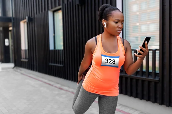 Akıllı telefon esneme hareketleriyle bayan maraton koşucusu — Stok fotoğraf