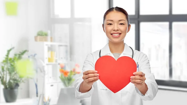 Sourire asiatique femme médecin tenant rouge coeur — Photo