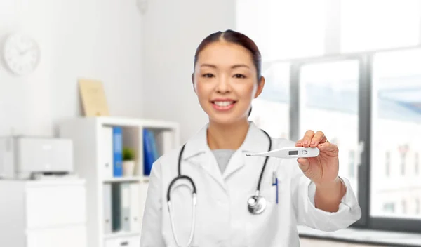 Sorrindo asiático feminino médico com termômetro — Fotografia de Stock