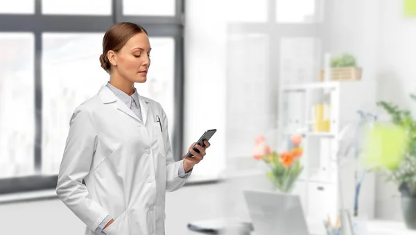 Женщина-врач со смартфоном в больнице — стоковое фото