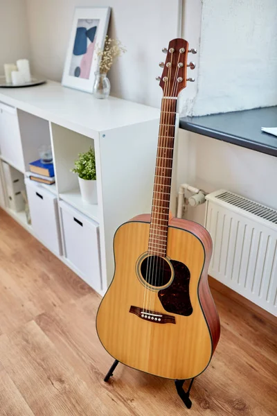 Close up of acoustic guitar on stand at home — Stock Photo, Image