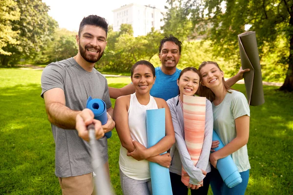 Mensen met yogamatten die selfie nemen in het park — Stockfoto